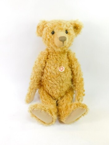 A Steiff plush jointed teddy bear, with button to ear and label to body, 58cm high.