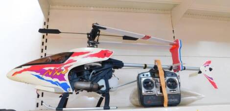 A Nexus NXS Kyosho remote control helicopter XP642, probably a 30 series, partially decorated, with remote control, 121cm wide (AF).