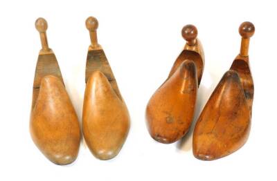 Two pairs of late 19thC shoe lasts, each with hinged centres and cylindrical handles, 28cm wide. (2 pairs)