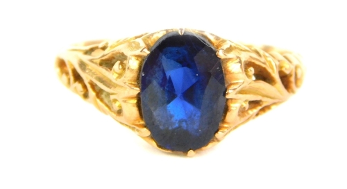 A sapphire set dress ring, with foliate carved shoulders and yellow metal shank, 2.7g all in.
