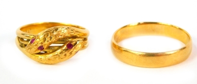 A Victorian gold wedding band with inscription, unhallmarked, 4.5g and an interlinked serpent ring, set with ruby eyes and in a yellow metal shank engraved 22C (2).