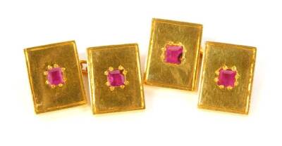 A pair of cufflinks, set with rubies and cast in yellow metal.