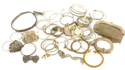 A quantity of mainly Indian and Eastern white metal, including bangles, slave and torc bracelets, chain mail evening purse, etc.