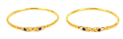 A pair of circular bangles, with enamel decoration, unhallmarked yellow metal.