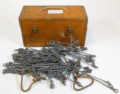 An unusual cricket pitch measuring chain, with shaped links, in rectangular box, 14cm high, 33cm wide, 14cm deep.