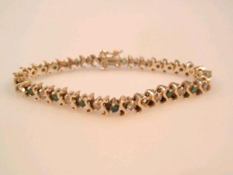 An emerald and diamond set tennis bracelet