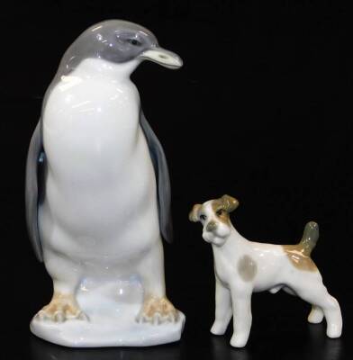 A Lladro pottery figure of a penguin, E-20, marked beneath, 14cm high, and a Lladro style figure of a dog no. 8443. (2)