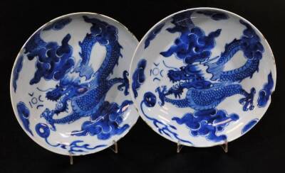 A pair of Chinese porcelain dishes, each of circular form decorated with four clawed dragons in cloud and floral setting, each with double line six character Chenghua marks beneath, 18cm diameter.