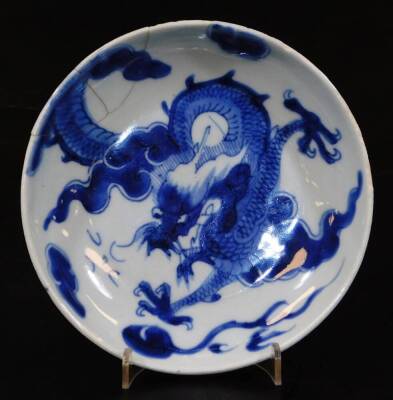 A Chinese porcelain blue and white saucer dish, of circular form decorated with a four clawed dragon in a cloud setting, double line seal mark beneath, 16cm diameter. (AF)