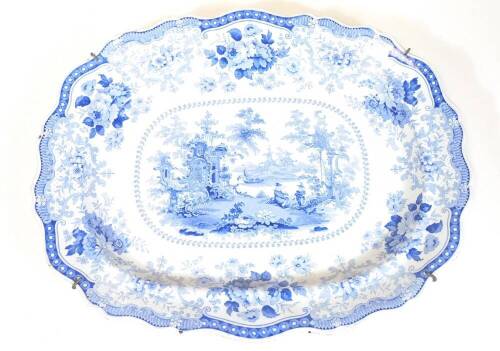 A 19thC Fairy Villas blue and white meat platter, with shaped border, the centre transfer printed with figures, trees and building, printed marks beneath, 55cm wide.