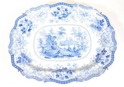 A 19thC Fairy Villas blue and white meat platter, with shaped border, the centre transfer printed with figures, trees and building, printed marks beneath, 55cm wide.
