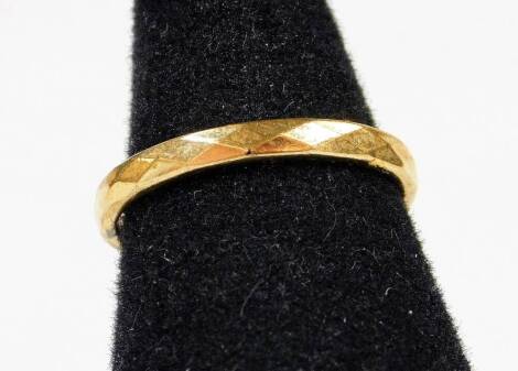 A textured band, marked 18ct, size L, 1.5g.