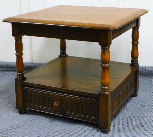 A late 20thC Ercol side table, the shaped top on turned legs with a drawer beneath, 50cm high, 58cm wide, 58cm deep.