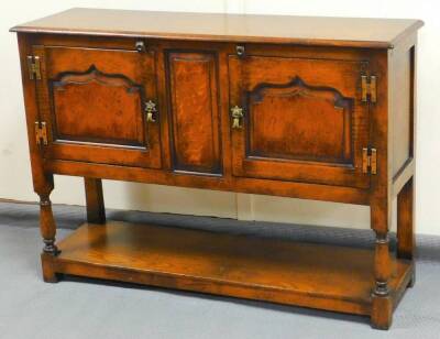 A 20thC Stanley Cumper oak cabinet, with central panel flanked by cupboard and baluster legs joined by an undertier, 77cm high, 107cm wide, 34cm deep.