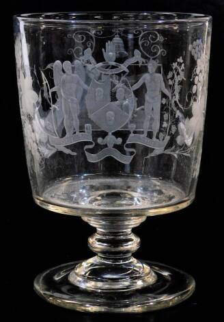 A early 19thC etched Masonic oversized glass goblet, with bell shaped bowl, profusely decorated with a coat of arms Qui Ridis, set with figures, further etched with leaves and berries, and with a panel of etched stag, on a turned stem and plain foot, 24cm