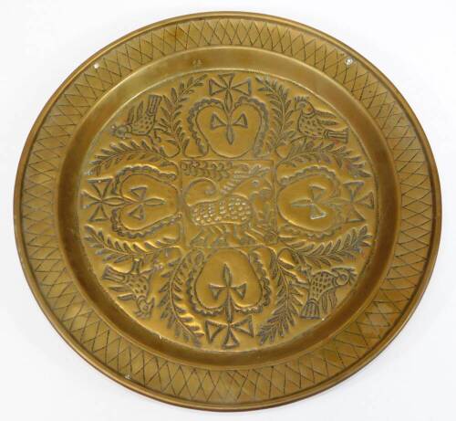 A 19thC continental brass charger, embossed and engraved with heart and cross motifs, birds and leaves, 45.5cm diameter.