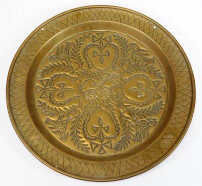 A 19thC continental brass charger, embossed and engraved with heart and cross motifs, birds and leaves, 45.5cm diameter.