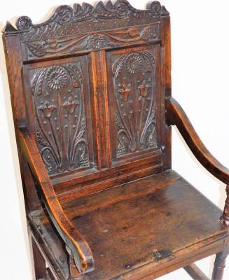 A principally late 17thC oak Wainscot chair, with a scroll cresting rail, raised above two panels of flowers, with scroll arms on turned supports, the plain seat raised turned on turned legs, terminating in block feet, joined by block stretchers, with lat - 2