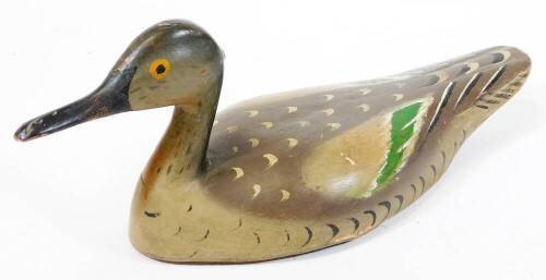 An early 20thC folk art wooden decoy duck, with painted plumage predominantly in green and grey, probably French, 16cm high.