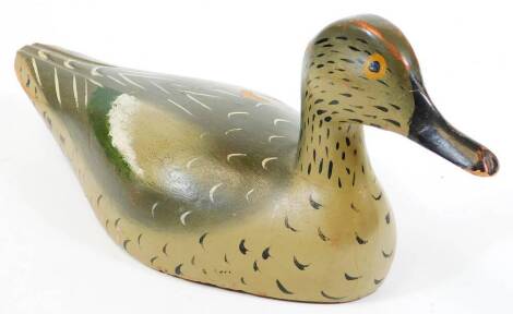 An early 20thC folk art wooden decoy duck, with painted plumage predominantly in green and grey, probably French, 15cm high.