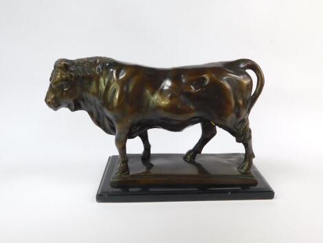 A bronze cast figure of a bull, modelled in standing pose, on a rectangular base, raised on a further stepped rectangular black marble base, 31cm H, 49cm W, 19cm D.