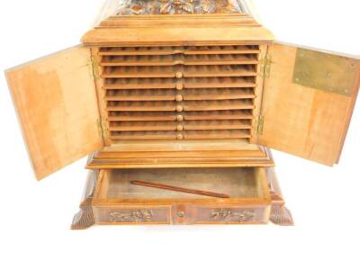 A late 19thC Black Forest wooden cigar chest, the top carved with game birds, above two doors opening to reveal nine sliding shelves, above a frieze drawer, raised on leaf scroll feet, 45cm H, 29.5cm W, 16cm D. - 2