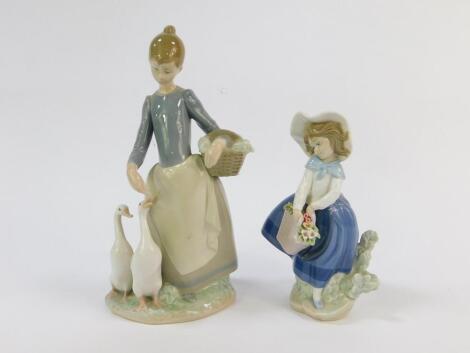 A Lladro porcelain figure modelled as girl feeding two ducks, 25cm high, and a further figure of a girl with a basket of flowers, 18cm high. (2)