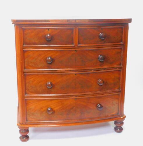A Victorian mahogany bow front chest, of two short over three long drawers raised on turned feet, 120.5cm H, 114cm W, 55cm D.