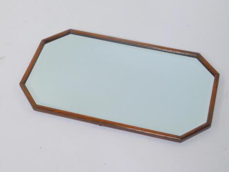 A mid 20thC oak wall mirror, of octagonal form, inset bevel glass, 14.5cm wide, 68cm high.