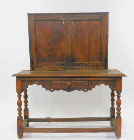 A 17thC and later oak side table, with a paneled splash back, carved frieze with single frieze drawer, raised on turned legs, united by box stretcher, 134cm High, 118cm Wide, 53cm Deep.