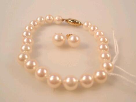A pearl bracelet, with clasp stamped 375, 19cm, and matching earrings