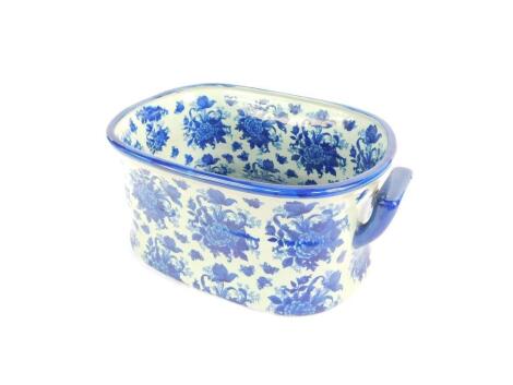 A reproduction blue and white pottery foot bath, printed in blue and white with sprays of flowers, 47cm W, 31cm D.