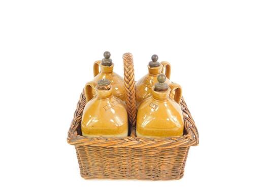 A set of four Victorian stoneware two tone spirit jars, in a four division wicker basket, comprising Scotch Whisky, Brandy, Gin, and Irish Whiskey, registration lozenge for 5th October 1877.