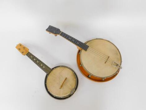 A wooden cased banjo ukulele, and a metal cased banjo ukulele, 59cm and 54cm H respectively. (2)