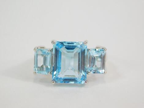 A silver blue and white topaz three stone ring, the square and baguette cut stones in a stepped, claw setting, 2.15cts, size O, with certificate.