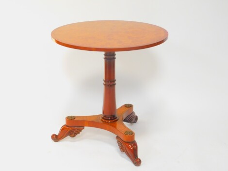 An Empire style burr elm and mahogany cross banded occasional table, the circular top raised on turned column and triform base raised on leaf carved cabriole legs, 72cm H, 68.5cm Dia.