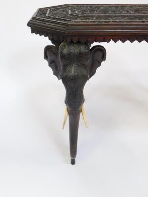 An Anglo Indian late 19thC hardwood occasional table, of canted rectangular form, the top carved with bands of figures, elephants, flowers and foliate scrolls, raised on four elephant's head scroll feet, 61cm H, 92cm W, 46cm D. - 3