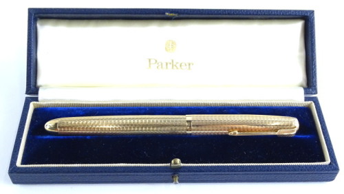 A Parker 51 9ct gold fountain pen, with engine turned decoration, stamped 9, 0.375, in blue leather case, 14cm long.