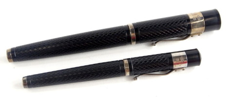 Two Yard-O-Led black and silver mountain fountain pens, of differing sizes.