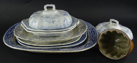 A collection of 19thC Staffordshire blue and white ceramics, to include Willow pattern meat dishes, Asiatic meat dish and a pair of tureens and covers, and a 19thC stoneware jelly mould decorated with a fish.