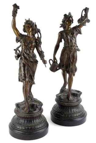 A pair of late 19thC French cold painted spelter figurines, one modelled in the form of a lady carrying grapes etc., the other a gentleman with a watering can and a basket (AF), each on a circular base, 54cm high.