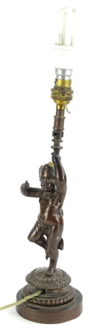 A 19thC bronze lamp base, modelled in the form of a putto, holding the fitting on a circular base, 36cm high to top of fitting.