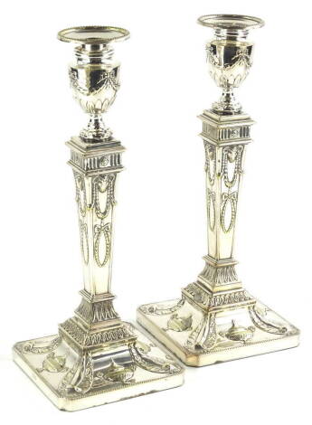 A pair of silver plated candlesticks, modelled in neo classical style, in the manner of Robert Adam, with swags, rams heads, etc., 31cm high.