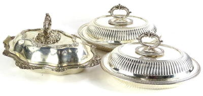 Three silver plated tureens, to include a pair, each with a beaded handle and gadrooned borders and another with rococo scroll handle, borders, etc., a large early 20thC silver plated warming meat dish, of oval form with gadrooned border and shaped handle