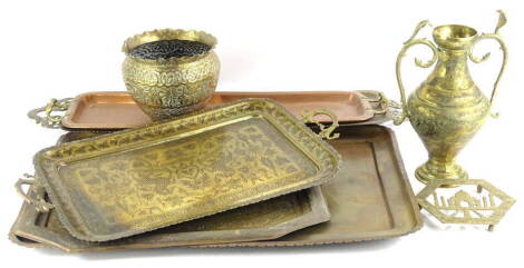 Various Indian brass and copper trays, each with elaborate decoration, an embossed and repousse decorated jardinere, a trivet with pierced decoration of the Taj Mahal, etc.