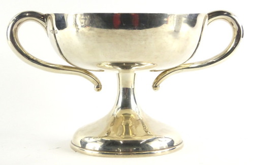 An Edwardian silver two handled cup, with shaped handles, waisted column, and domed foot, unengraved, Chester 1908, 23¼ oz, 23cm wide.