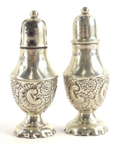 A pair of late Victorian small pepper pots, each with embossed C scroll decoration, Birmingham 1897, ¾oz, 7cm high.