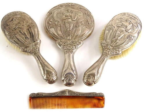 An early 20thC associated silver mounted dressing table set, each piece with a design of an Art Nouveau style lady holding a zither, surrounded by tulips, etc., in typical fashion, hallmarks for Birmingham and Chester, various makers, (4).