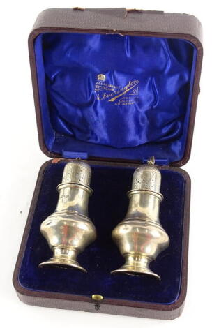 A pair of Edwardian silver sugar castors, each of baluster form, the lid with Howard decoration, London 1905, (AF).