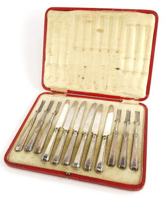 A set of six George V silver handled dessert knives and forks, with silver plated blades, Sheffield 1917, in red simulated leather case.